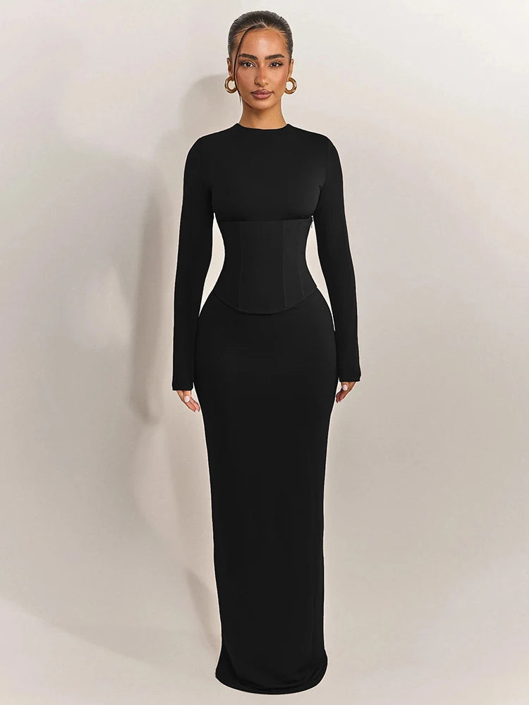 Woman wearing a black long-sleeve dress against a white background