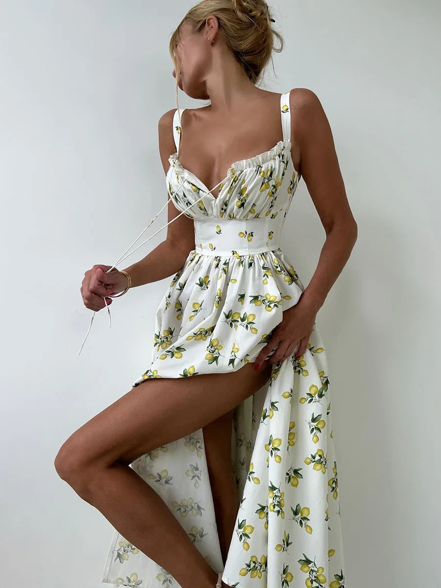 Woman wearing a white dress with yellow floral pattern against a plain background