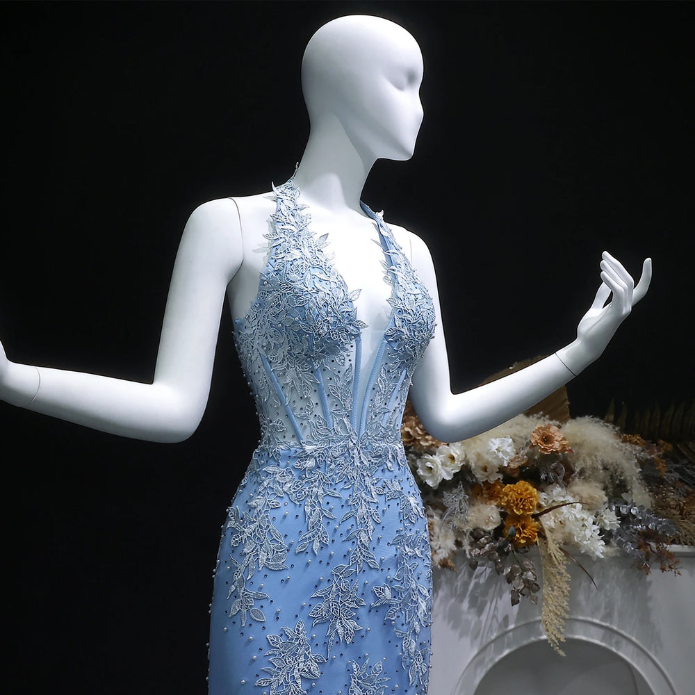 Mannequin wearing a blue evening gown with floral embroidery against a dark background