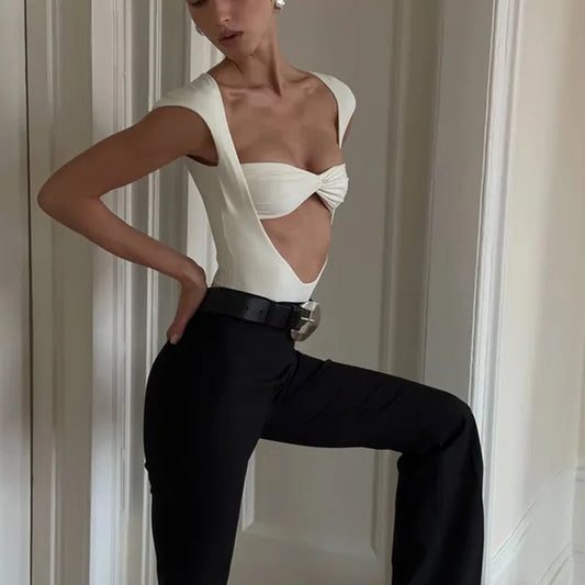 Model posing in a white twisted bustier cutout bodysuit