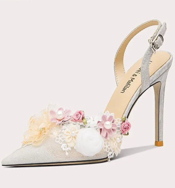 High-heeled shoe with floral decorations on a white background