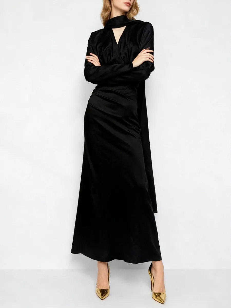 Woman wearing a black dress with long sleeves on a white background