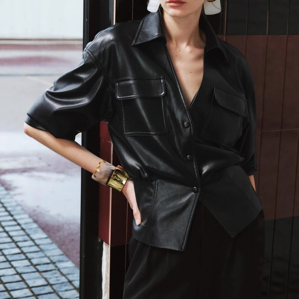 Person wearing a black leather outfit with a blurred background