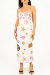 Woman wearing a white dress with colorful shell patterns on a white background