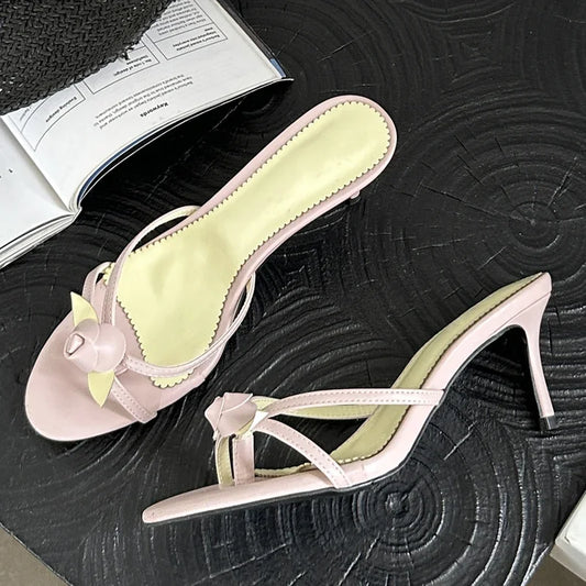 Pink heeled slides with a floral embellishment