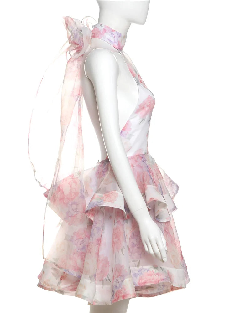 Mannequin wearing a pink floral dress with a sheer overlay on a white background