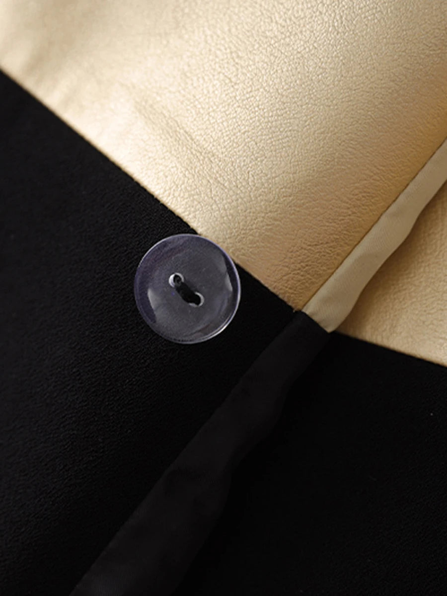 Close-up of a button on a garment with a black, beige, and white color scheme.