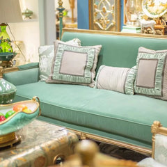 Teal sofa with decorative pillows in a decorated room