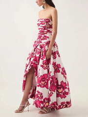 Woman wearing a strapless floral dress with a high-low hem on a white background