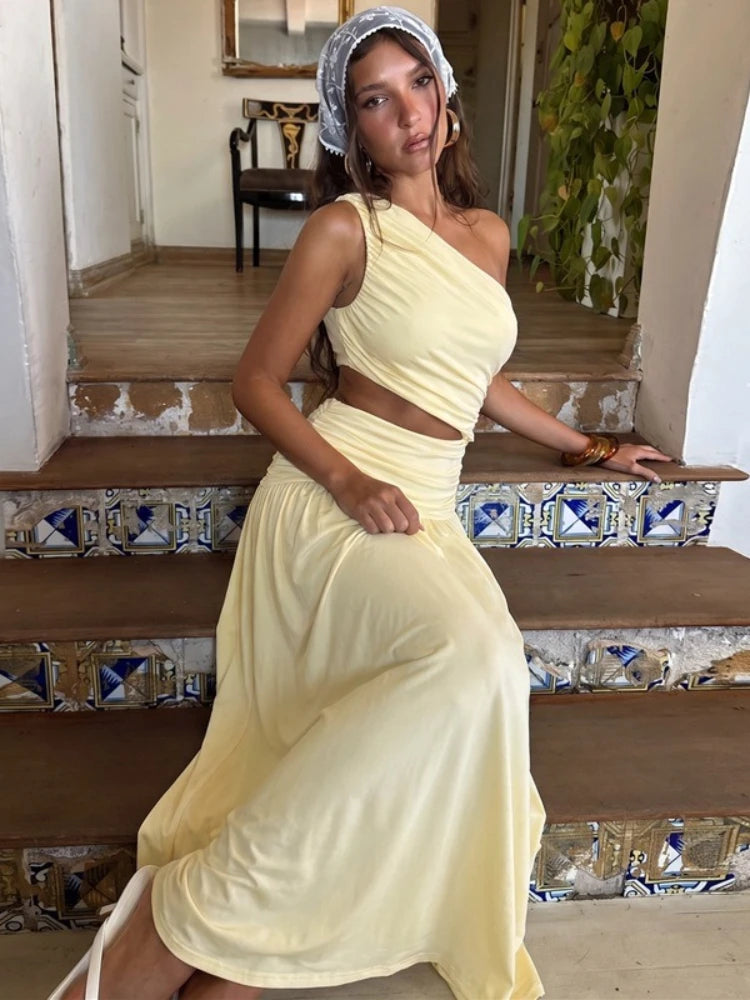 One-shoulder cutout ruched maxi dress on a woman sitting on stairs.