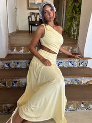 One-shoulder cutout ruched maxi dress on a woman sitting on stairs.