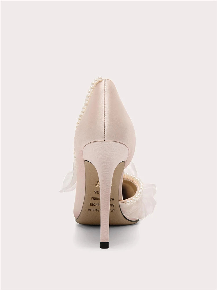 Beige high-heeled shoe with decorative elements on a white background