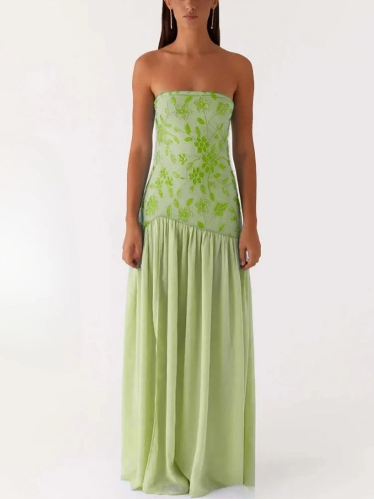 Woman wearing a strapless green floral dress on a white background