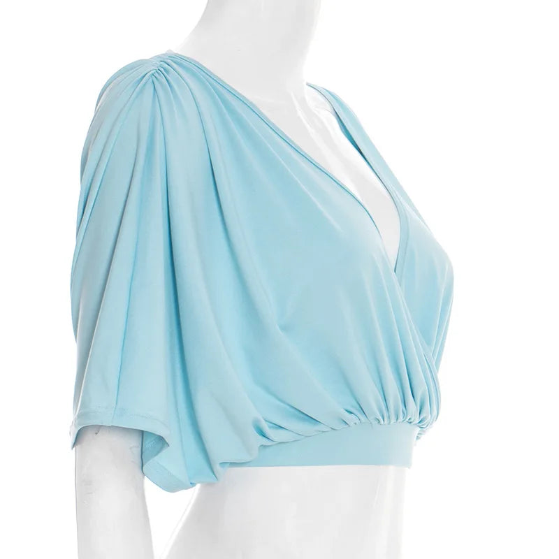 Light blue draped top on a mannequin against a white background