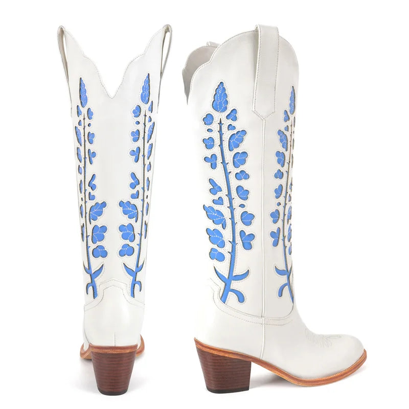 White cowboy boots with blue floral patterns on a white background