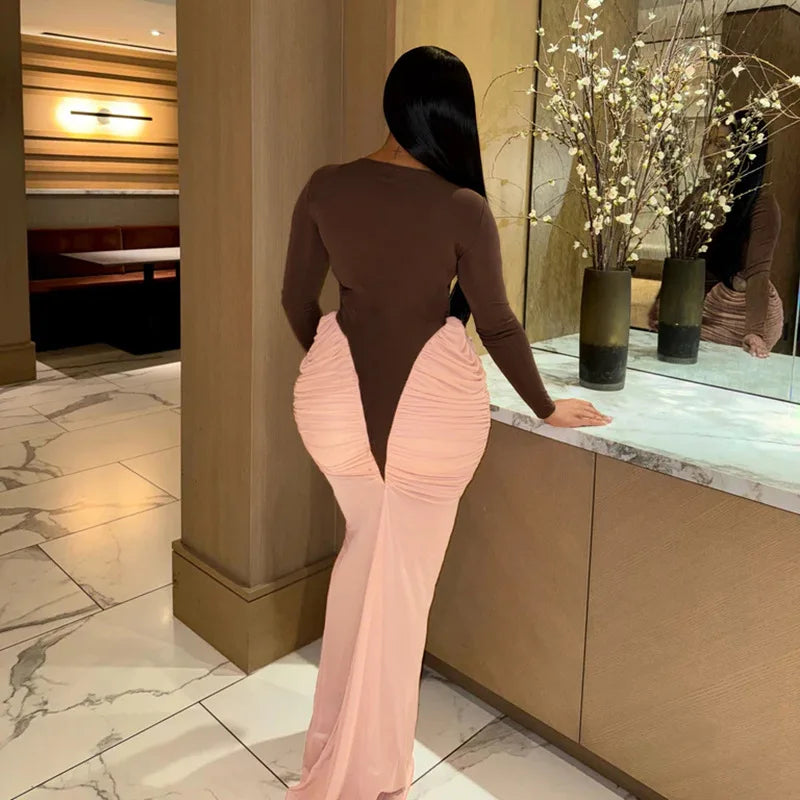 Person wearing a brown top and pink pants in a modern interior setting.