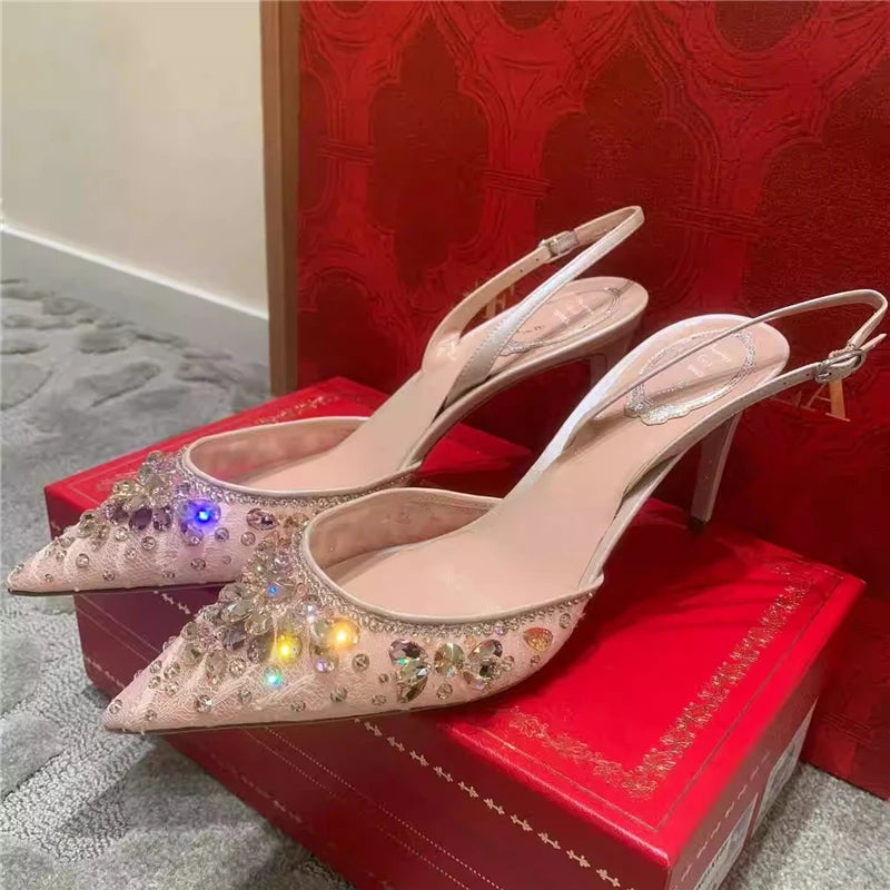 Pair of high-heeled shoes with rhinestone details on a red box.