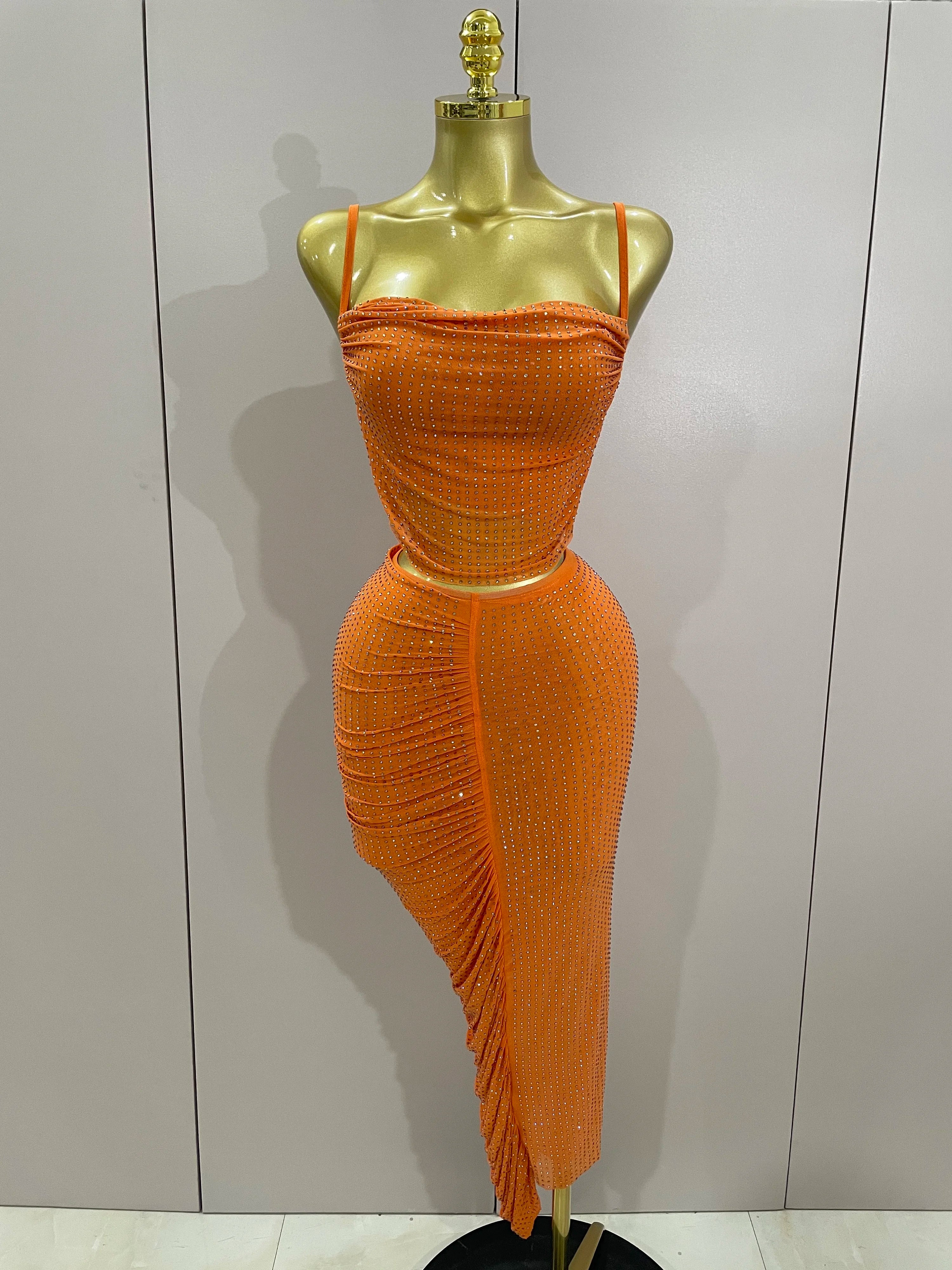 Orange dress on a mannequin against a plain background