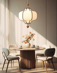 Dining room with round table, chairs, and a hanging lamp.