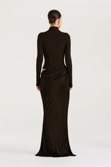 Woman wearing a long black dress with a high neckline on a white background