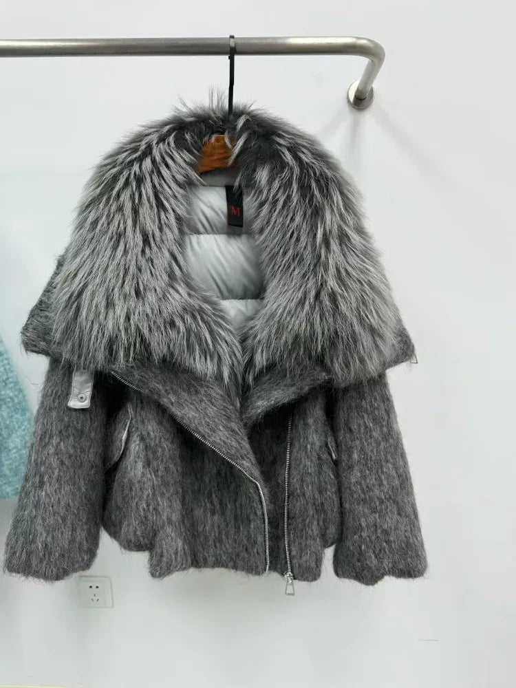 Gray knitted jacket with fur collar on a hanger against a white wall.