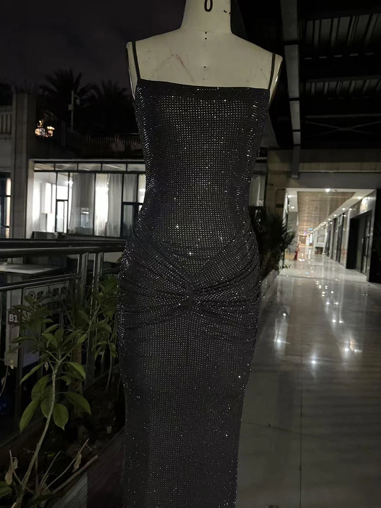 Black sequin dress on a mannequin in an indoor setting with plants and furniture.