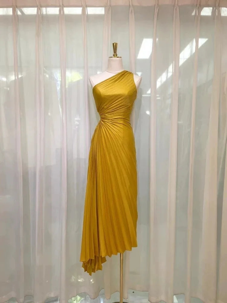 Golden yellow asymmetrical one-shoulder gown on a mannequin.