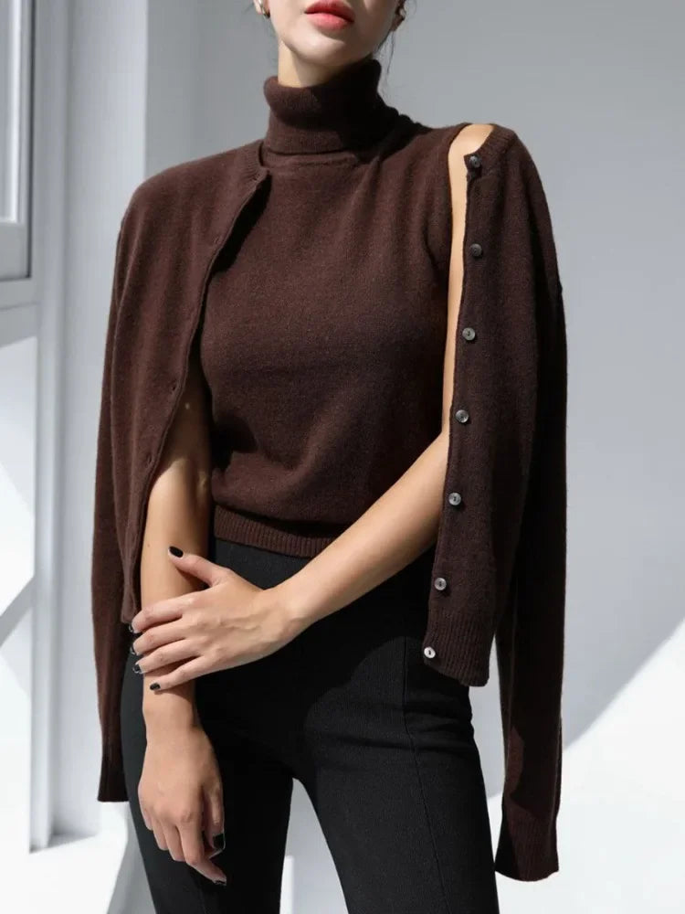 Woman wearing a brown turtleneck sweater with a matching cardigan over a white background