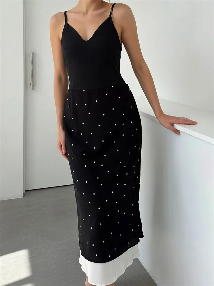 Model in a polka dot midi skirt with a black camisole.