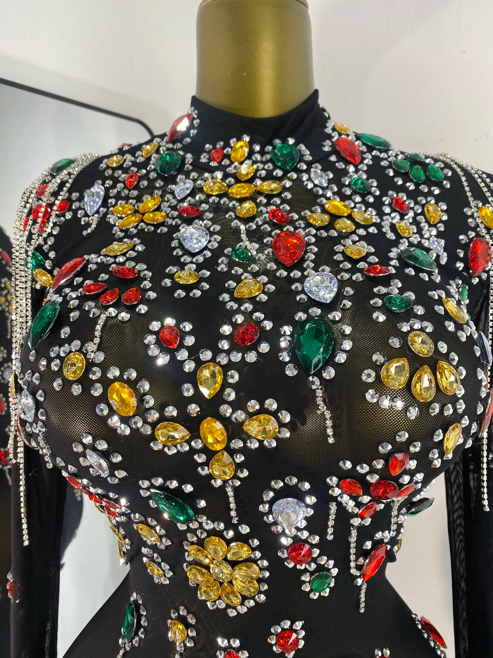 Close-up of colorful rhinestone embellishments on black mesh mini dress