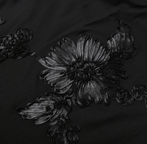 Black floral embroidery on a dark fabric background