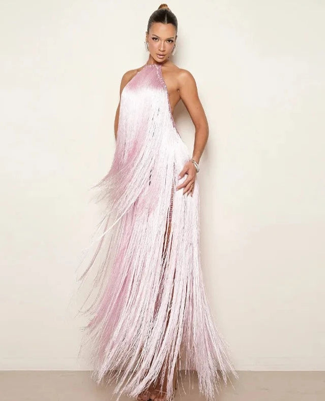 Woman wearing a pink fringe dress against a plain background