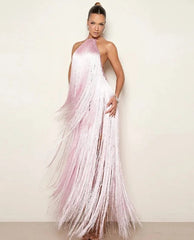 Woman wearing a pink fringe dress against a plain background