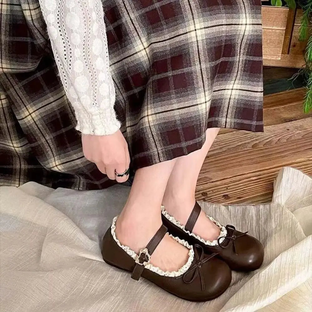 Person wearing brown lace ruffled bow Mary Jane flats