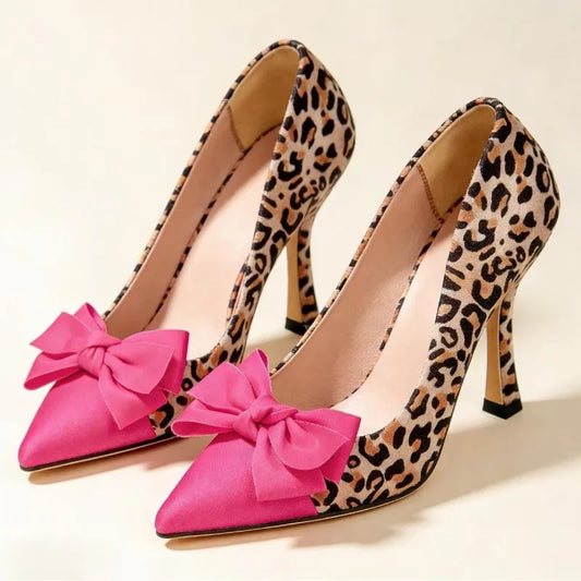 Leopard print pointed toe pumps with a pink bow accent.