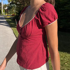 Person wearing a red checkered top outdoors