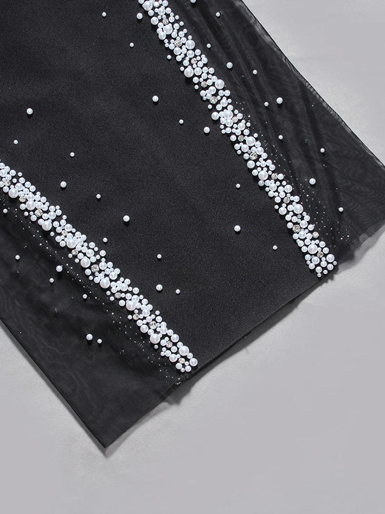 Black fabric with white pearl embellishments on a gray background