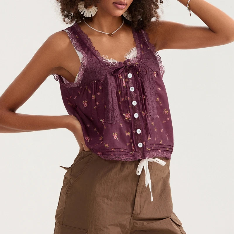 Woman wearing a patterned purple top with lace details and brown pants on a white background