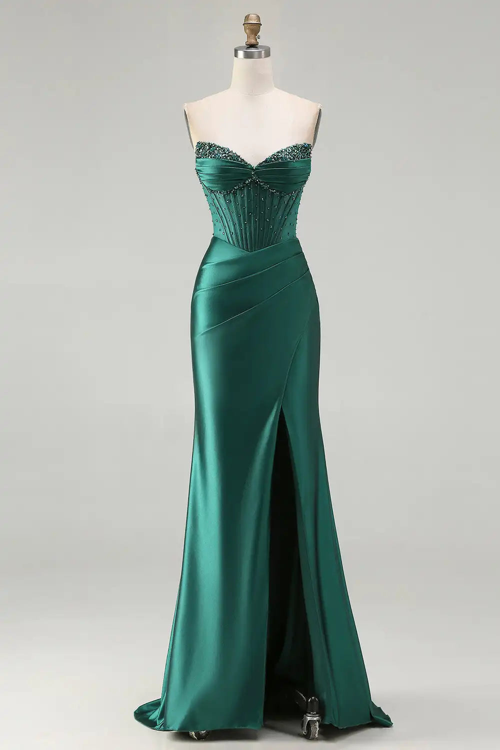 Green evening gown on a mannequin against a white background