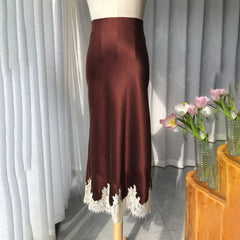 Brown satin skirt with lace hem on a mannequin against a white curtain background.