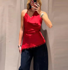 Person wearing a red top and dark pants against a plain background