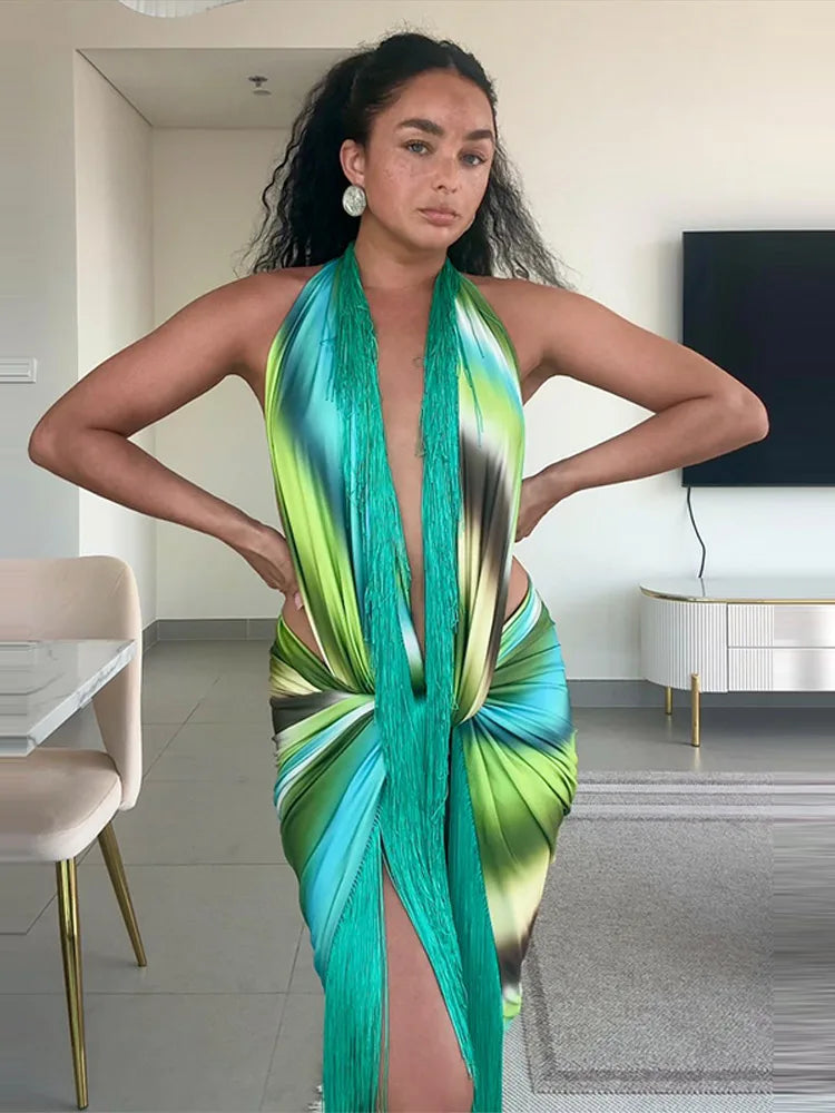 Woman wearing a printed halter fringe maxi dress indoors with hands on hips