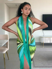 Woman wearing a printed halter fringe maxi dress indoors with hands on hips