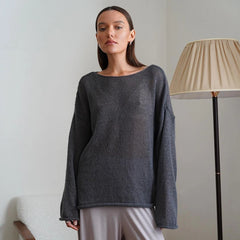 A woman wearing a stylish Dark  Grey transparent knit sweater with long sleeves, perfect for fall layering. Golden Atelier 3