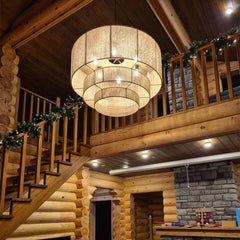 A rustic Wabi-Sabi hemp rope chandelier hanging in a modern living room with exposed wood walls. 2