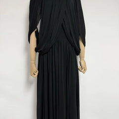 Black draped dress on a mannequin against a white background