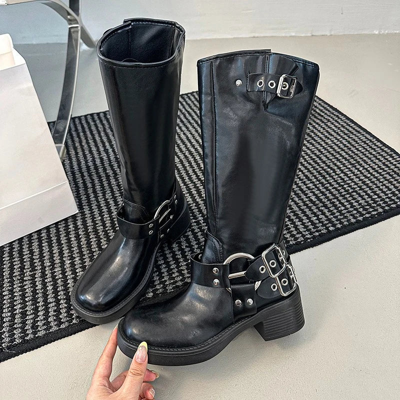 Black knee-high boots with buckles on a textured mat