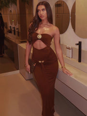 Woman in a brown dress standing in a bathroom.
