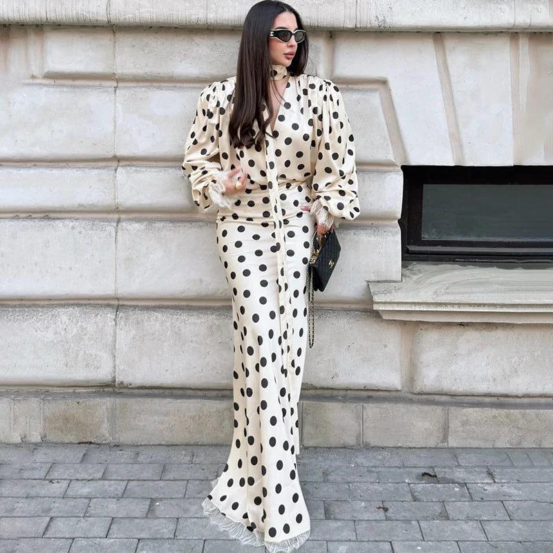 Model wearing a polka dot satin puff sleeve blouse and maxi skirt set outdoors