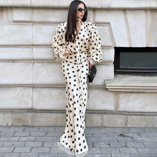 Model wearing a polka dot satin puff sleeve blouse and maxi skirt set outdoors
